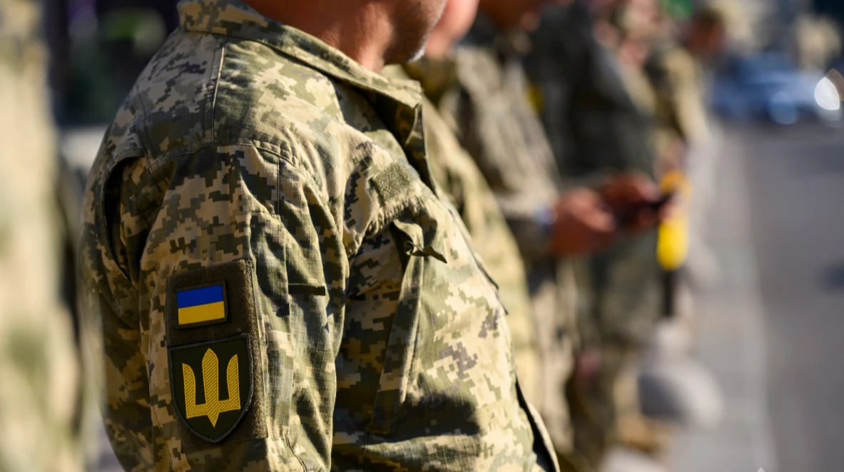 Українські військовослужбовці ЗСУ на тлі військової техніки